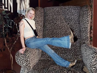 Jane Widdop is sitting in the arm of a very huge sofa.